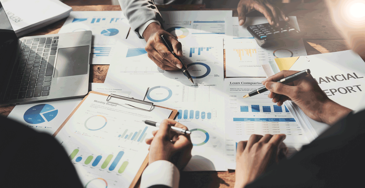 Business People Meeting using laptop computer,calculator,notebook,stock market chart paper for analysis Plans to improve quality next month. Conference